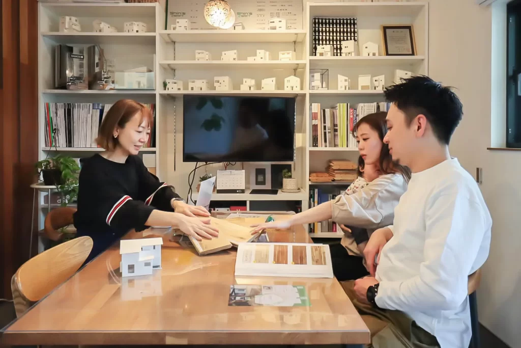 シンズクラフトの女性建築士が素材を見せながらお客様と打ち合わせをしている写真