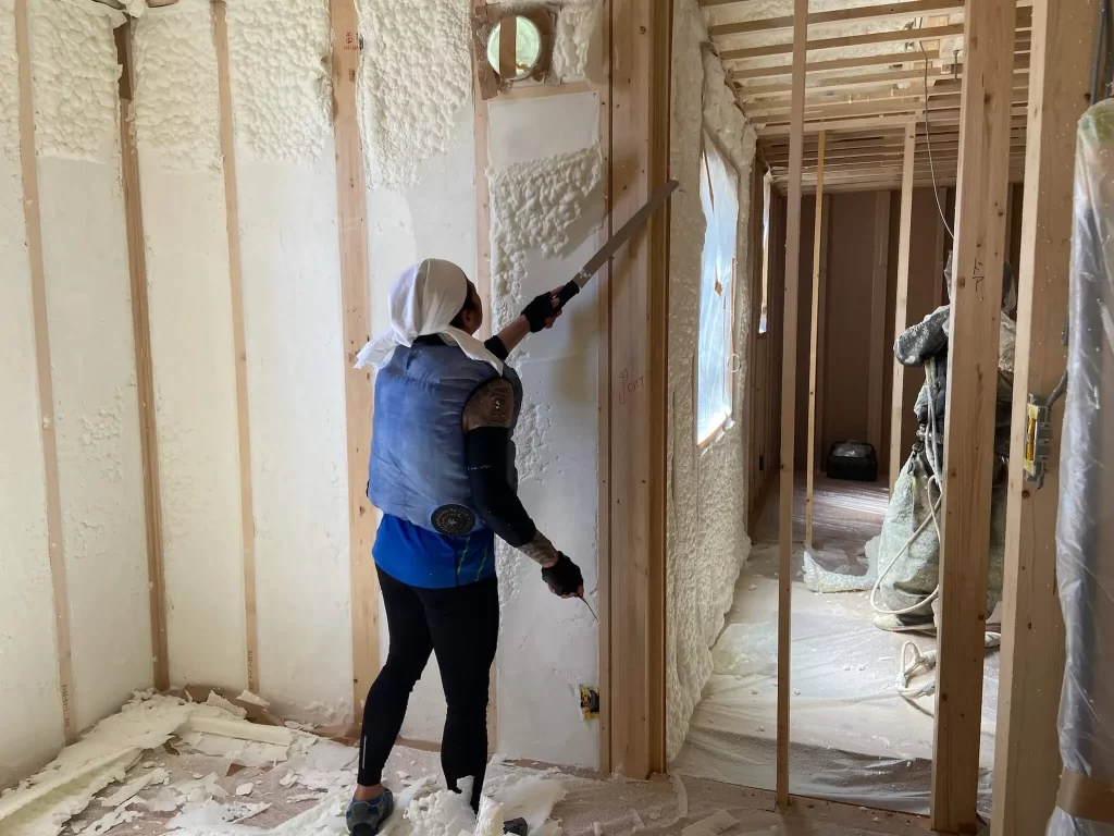 シンズクラフトで建築中の物件で余分な断熱材を切っている写真