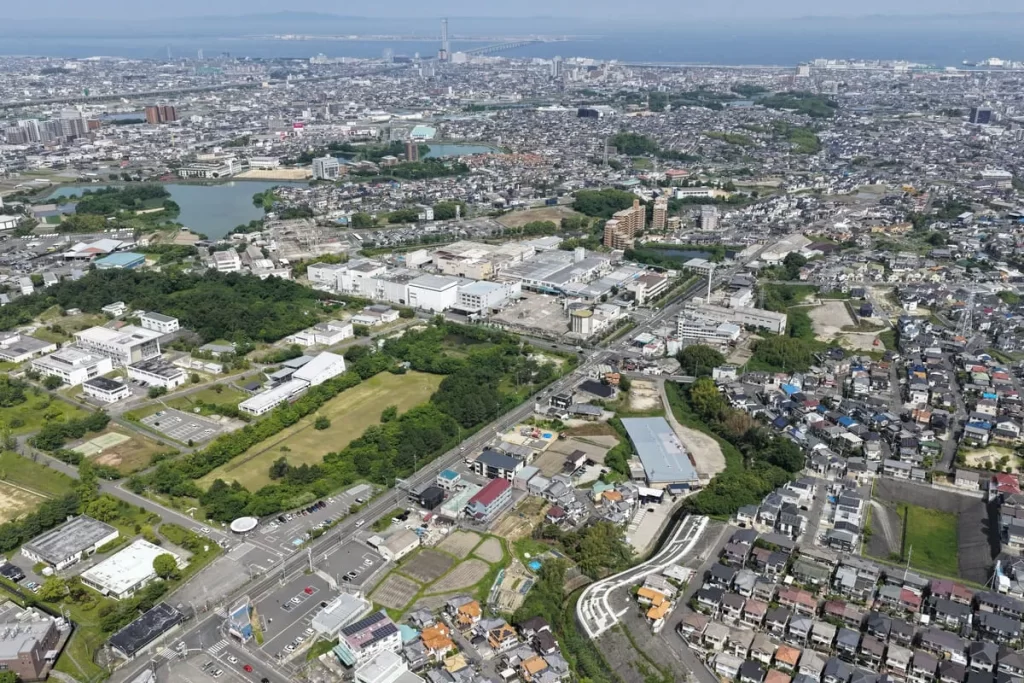 住宅や田畑、商業施設が広がる街並みを上空から撮影した俯瞰写真で、注文住宅を建てる際の周辺環境の確認や土地探しの広域的なイメージを表現したもの。