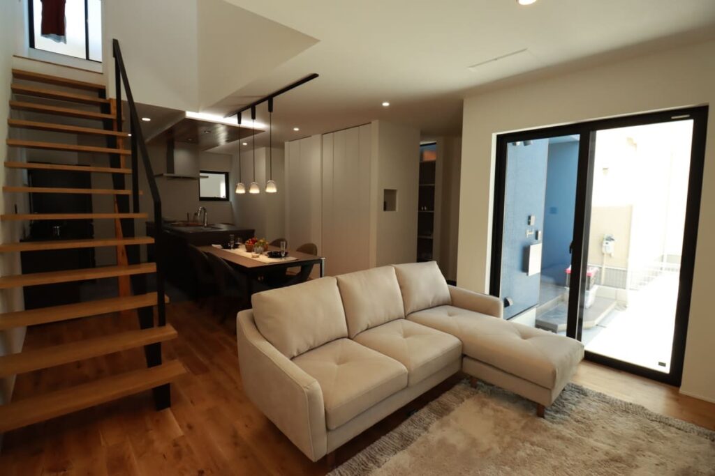 リビング階段と大きな窓を配置し、視覚的な広がりを持たせた狭小住宅のLDK空間。