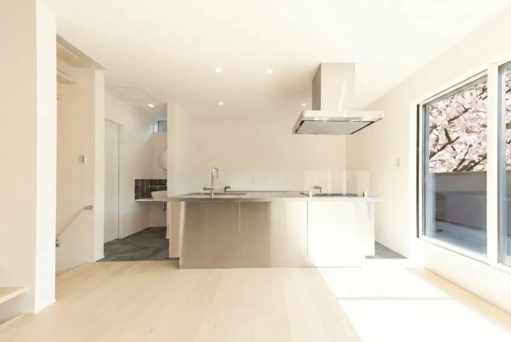 窓から桜が見える明るいアイランドキッチンのあるLDK。シンズクラフトが手がける開放的な注文住宅の内観。