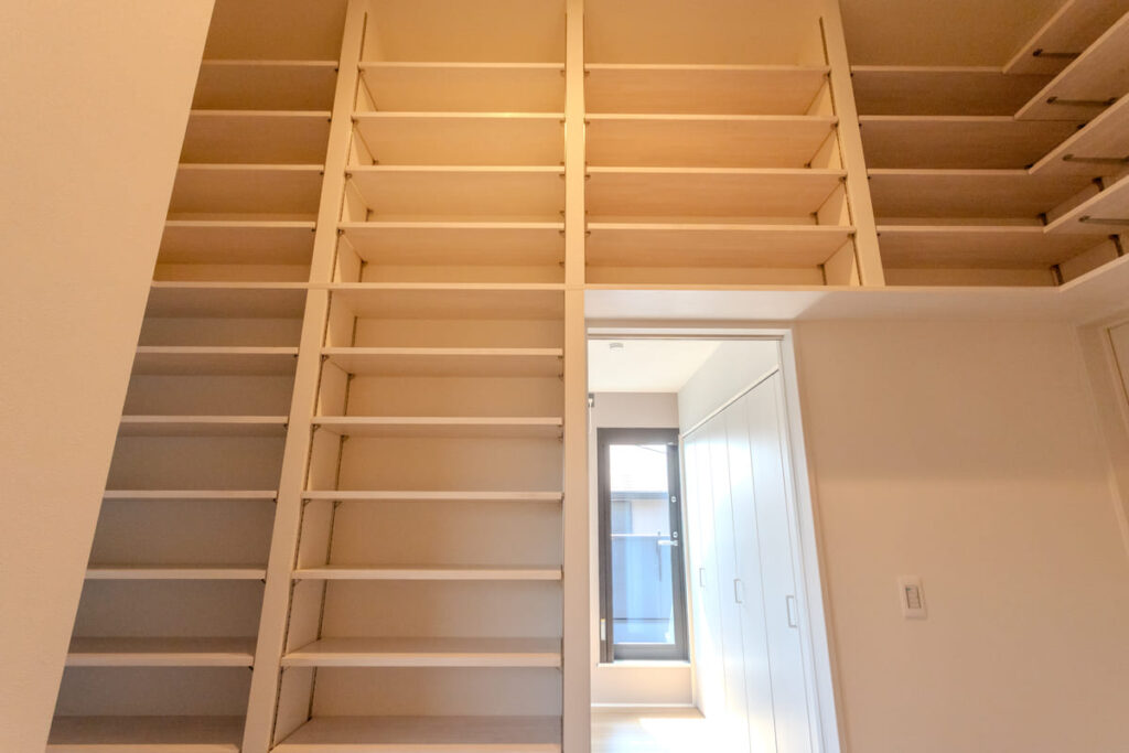 階段下のデッドスペースを有効活用し、数ミリ単位で調整された造作家具の壁面収納。